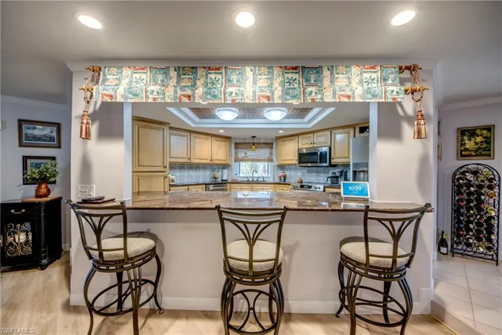 Spacious newly remodeled kitchen features gorgeous cabinetry and granite countertops, tray ceiling with crown molding, new Stainless appliances, a pantry. tile flooring, an open breakfast bar to the great room and a Gorgeous waterway and river view from the kitchen window.