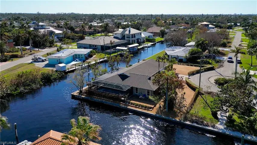 Delightful updated Pool home located on a quite cul-de-sac. Features approximately 239 Ft of water frontage just off the Caloosahatchee River. NO Bridges. Just minutes by boat to Sanibel, Back Bay or the Gulf of Mexico! Features Dock with 10 lb boat lift and davits for your smaller boat or jet skis. Meticulously maintained and upgraded. Wrap around Lanai with water views and sunset views from the Pool deck & Lanai!