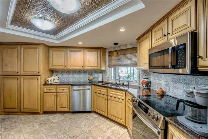 Spacious newly remodeled kitchen features gorgeous cabinetry and granite countertops, tray ceiling with crown molding, a pantry, new Stainless appliances, tile flooring, an open breakfast bar to the great room and a Gorgeous waterway and river view from the kitchen window.