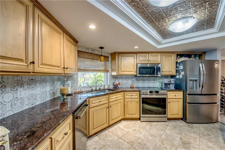 Spacious newly remodeled kitchen features gorgeous cabinetry and granite countertops, tray ceiling with crown molding, a pantry, new Stainless appliances, tile flooring, an open breakfast bar to the great room and a Gorgeous waterway and river view from the kitchen window.