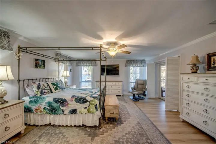 Spacious Master bedroom suite features LVP flooring, Large walk-in closet, Impact windows and Impact sliders to Lanai and pool area, Canal and River views, New en-suite bathroom with custom cabinetry, granite counters, new tile flooring, and elegant new shower.