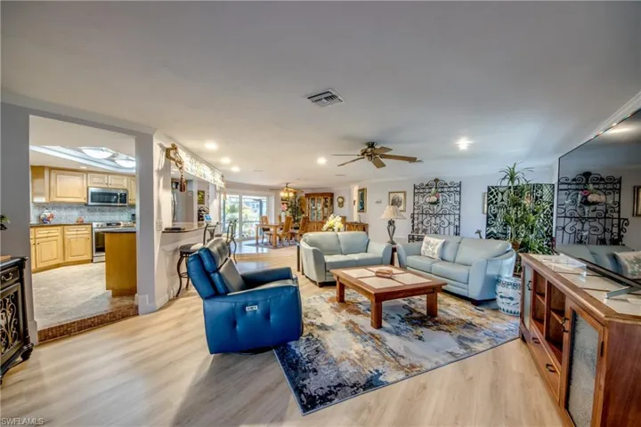 Looking in to the large great room and the spacious newly remodeled kitchen from the Lanai. Features include LVP flooring, crown molding, recessed lighting, and an open floor plan allowing a great flow for entertaining guest and family gatherings.