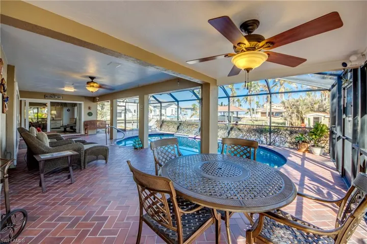 Large Pool with mansard cage and large unique wrap around covered Lanai featuring great water views to River Views and Gorgeous Sunsets! So much room for entertaining, seating, dining outside, relaxing in your lounge chair and enjoying the River breeze and gorgeous sunsets!