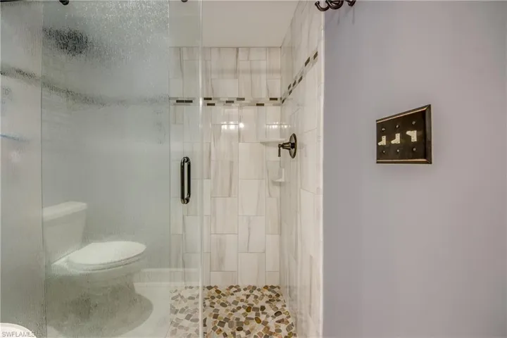 New master en-suite bathroom with custom cabinetry, granite counters, new tile flooring and elegant new shower.
