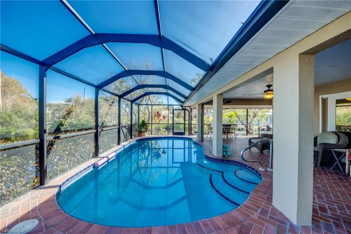 Large Pool with mansard cage and large unique wrap around covered Lanai featuring great water views to River Views and Gorgeous Sunsets!