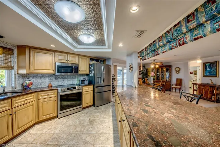 Spacious newly remodeled kitchen features gorgeous cabinetry and granite countertops, tray ceiling with crown molding, a pantry, new Stainless appliances, tile flooring, an open breakfast bar to the great room and a Gorgeous waterway and river view from the kitchen window.