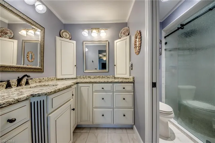 New master en-suite bathroom with custom cabinetry, granite counters, new tile flooring and elegant new shower.