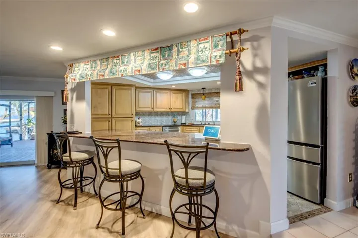 Spacious newly remodeled kitchen features gorgeous cabinetry and granite countertops, tray ceiling with crown molding, new Stainless appliances, a pantry, tile flooring, an open breakfast bar to the great room and a Gorgeous waterway and river view from the kitchen window.