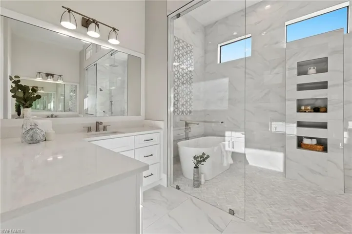 Bathroom with tile walls, vanity, and independent shower and bath