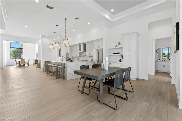 Dining space with ornamental molding, sink, and light hardwood / wood-style floors