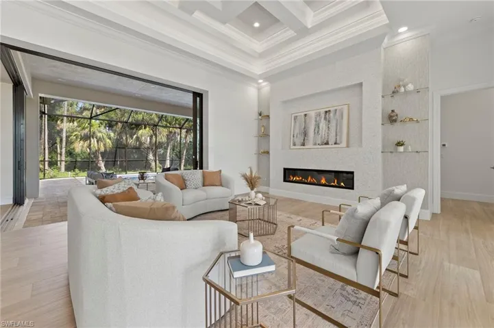 Living room featuring a large fireplace, coffered ceiling, beamed ceiling, and light hardwood / wood-style floors