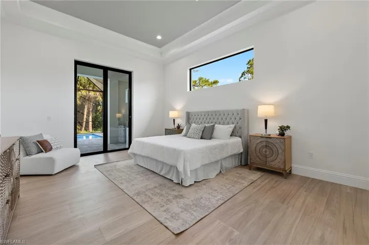 Bedroom with access to exterior, multiple windows, and light wood-type flooring
