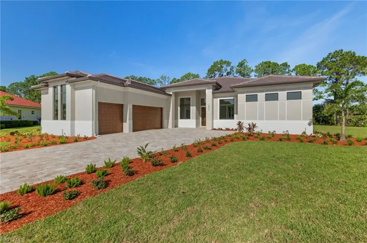 Prairie-style house featuring a front lawn and a garage