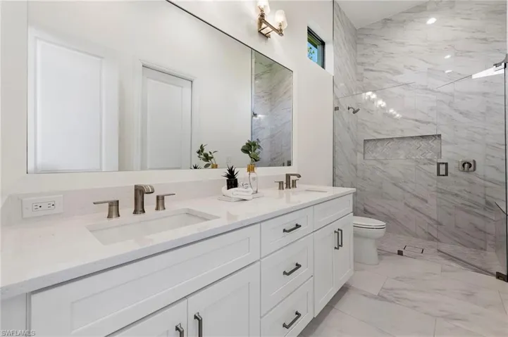 Bathroom featuring vanity, toilet, and an enclosed shower