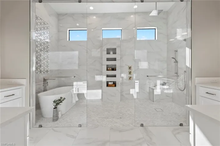 Bathroom with a wealth of natural light, vanity, and shower with separate bathtub