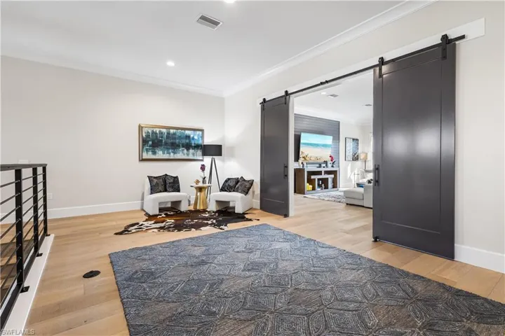 Barn doors lead into a fantastic exercise room/theater room. The choices are endless!
