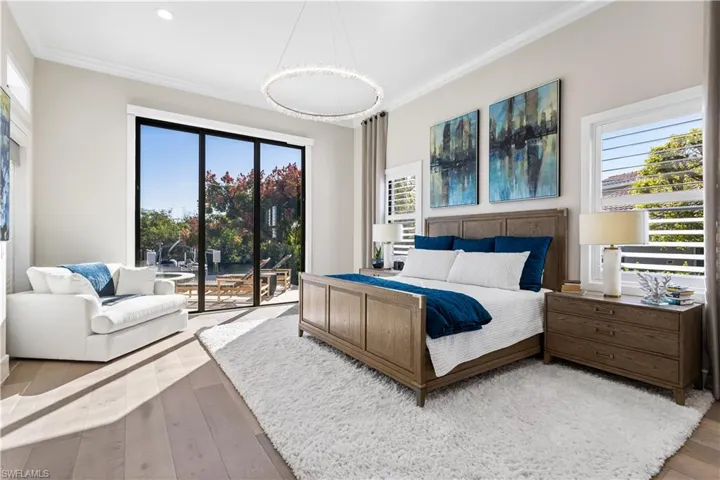 First floor Primary En-Suite w/White Oak flooring, 10ft stackable sliders to Pool-Hurricane Protection, Private door to pool, 2 oversized walk-in closets, windows w/Plantation Shutters.