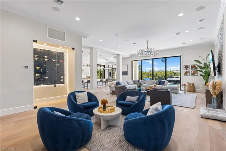 Wine wall with glass doors, 12ft Tray Ceiling 10ft stackable sliders Hurricane Protection- Electric Hurricane Shutters, White Oak flooring & Stacked stone TV entertainment wall.
