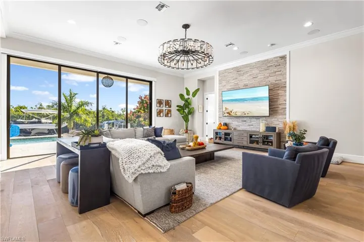 12ft Tray Ceiling 10ft stackable sliders Hurricane Protection- Electric Hurricane Shutters, White Oak flooring & Stacked stone TV entertainment wall.