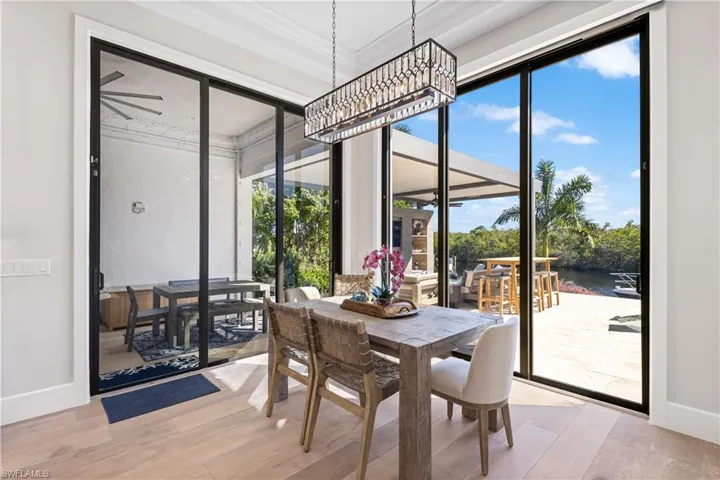 Dining area with pool and canal views. 10ft stackable sliders-Hurricane protection