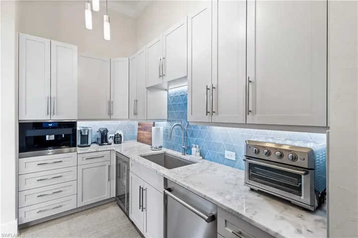 Butlers Pantry- White shaker cabinets, Quartz countertops, dry storage Pantry with shelving. Fully equipped w/ Miele Espresso machine, Zephr wine fridge. Asko dishwasher and a Cuisinart Countertop Oven!