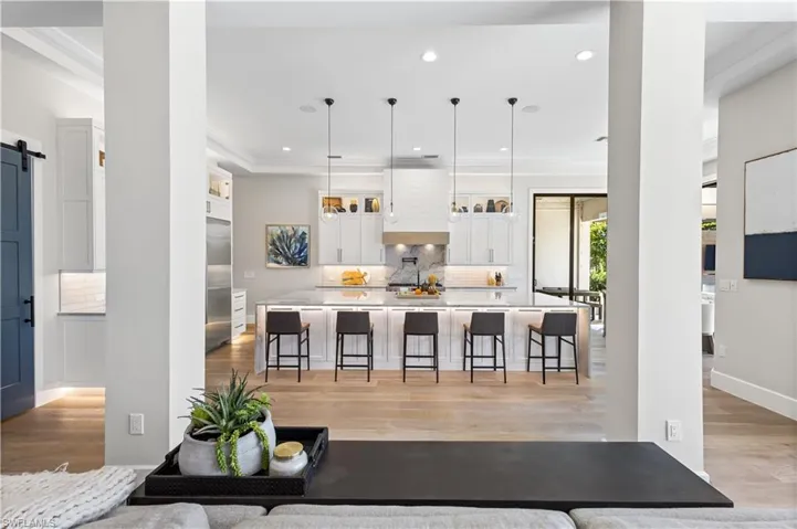 Spectacular oversized quartz countertop waterfall island measuring 14 ft. x 6.5ft. Custom wood cabinetry.