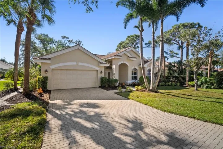 View of front facade with a garage and a front lawn