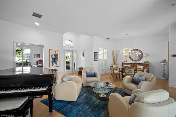Living room featuring a notable chandelier, plenty of natural light, and light hardwood / wood-style floors