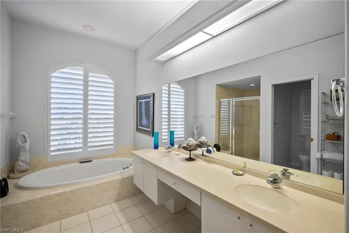 Full bathroom with tile patterned floors, vanity, plus walk in shower, and toilet
