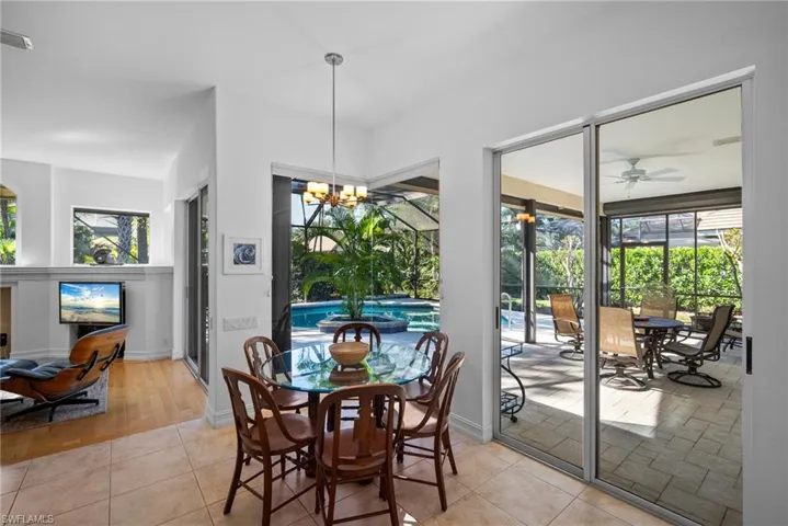 Dining area with plenty of natural light, light wood-type flooring, and ceiling fan with notable chandelier
