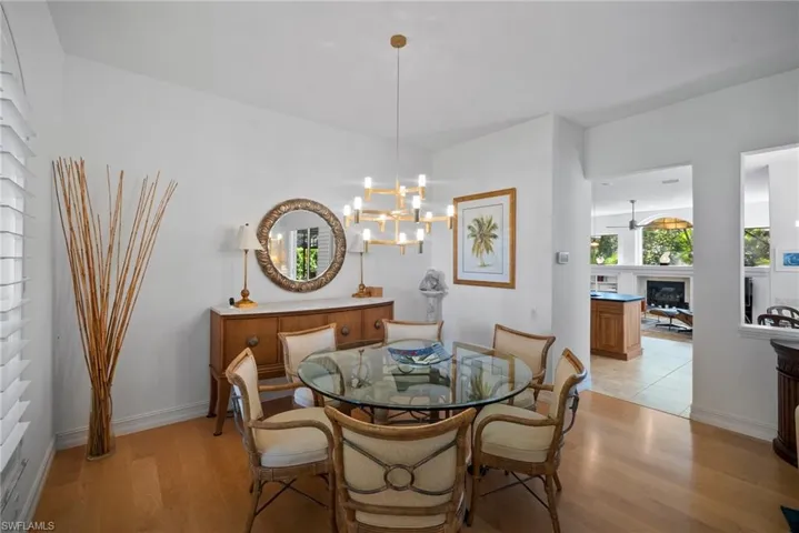 Dining area with ceiling fan with notable chandelier and light hardwood / wood-style floors