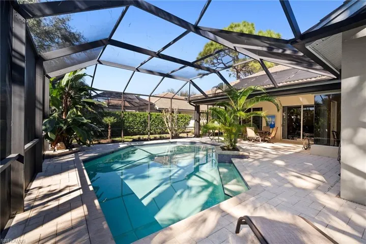 View of swimming pool featuring a lanai and a patio area
