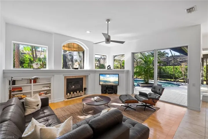 Living room with light hardwood / wood-style floors, ceiling fan, and a healthy amount of sunlight