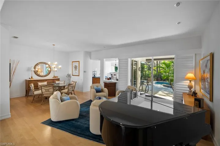 Living room with light wood-type flooring and a notable chandelier