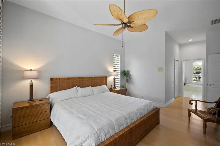 Bedroom with a closet, connected bathroom, light hardwood / wood-style floors, and ceiling fan