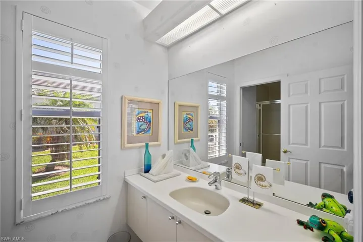 Bathroom featuring vanity, a healthy amount of sunlight, and a shower with door