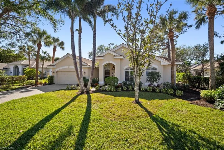 View of front facade featuring a front yard and a garage