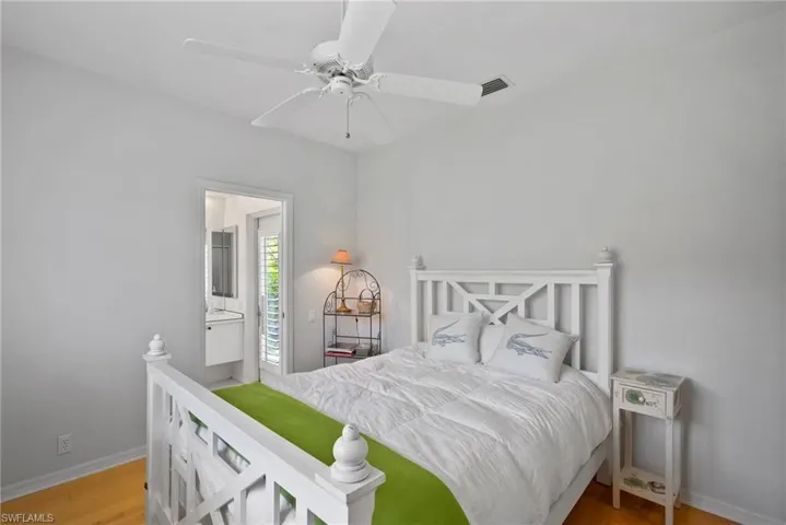 Bedroom featuring hardwood / wood-style flooring, ceiling fan, and connected bathroom