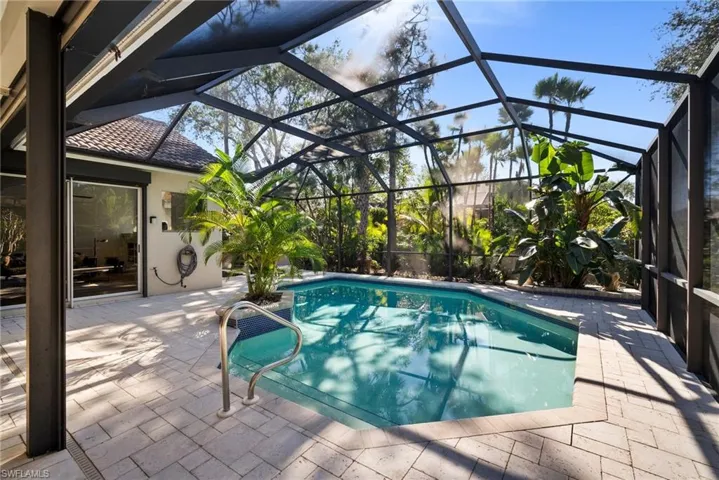 View of pool with a lanai and a patio area