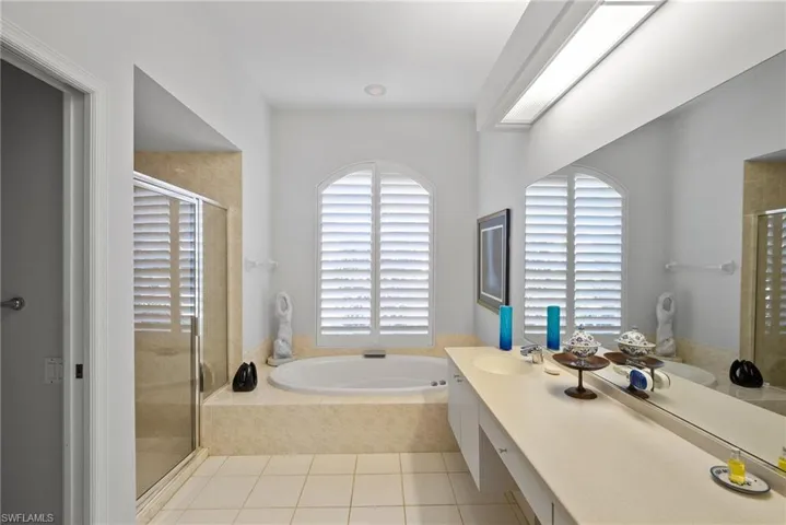 Bathroom featuring tile patterned floors, vanity, and independent shower and bath