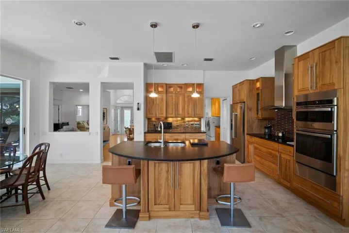 Kitchen featuring pendant lighting, a wealth of natural light, appliances with stainless steel finishes, and tasteful backsplash
