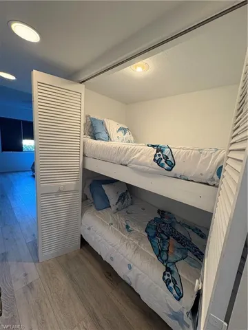 Bedroom featuring wood finished floors, a closet, and a textured ceiling