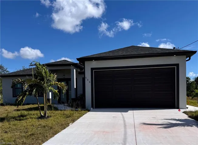 View of front of home with driveway, roof with shingles, an attached garage, and stucco siding