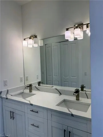 Full bathroom with double vanity and a closet