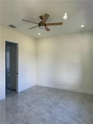 Empty room with baseboards and ceiling fan