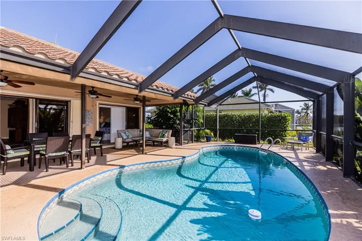 Outdoor pool featuring a patio area, glass enclosure, an outdoor living space, and a ceiling fan