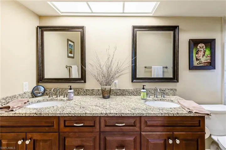 Full bath featuring double vanity, a sink, and toilet