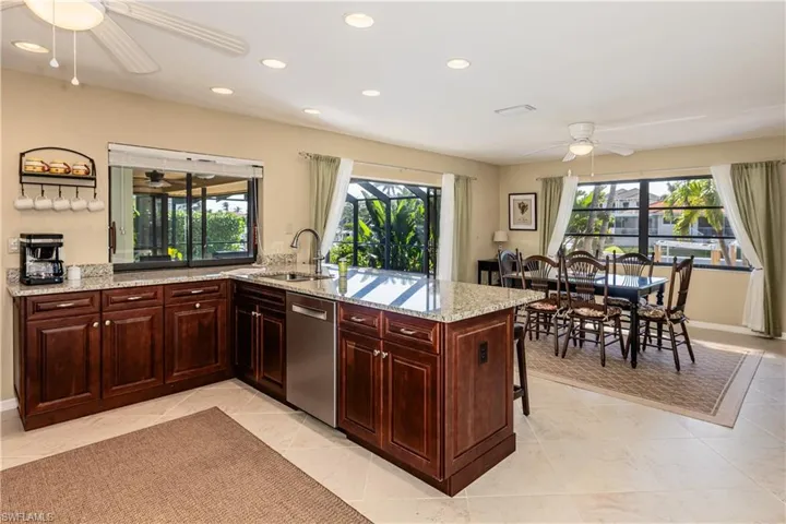 Kitchen with recessed lighting, a peninsula, a sink, a ceiling fan, and stainless steel dishwasher