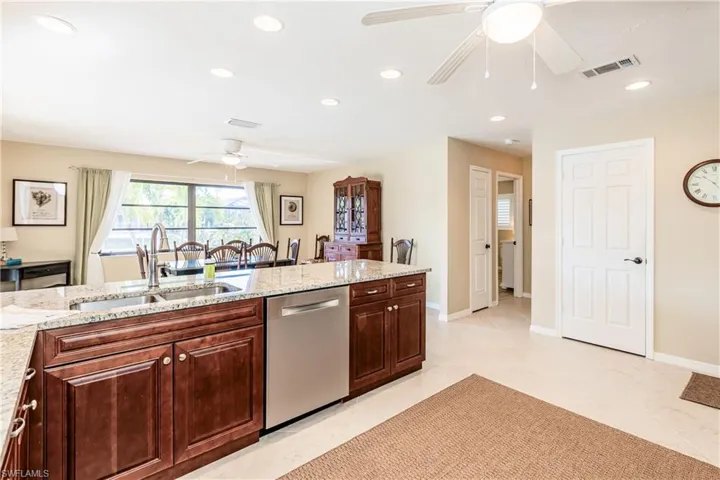 Kitchen featuring recessed lighting, visible vents, a sink, light stone countertops, and dishwasher