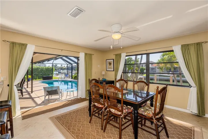 Dining room with visible vents, baseboards, a sunroom, and a healthy amount of sunlight